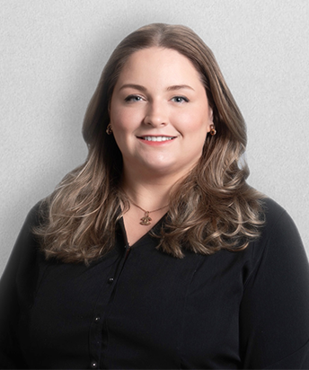 Professional headshot photo of Storey Gillen, wearing a black shirt against a white background