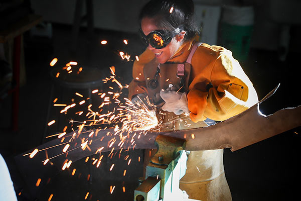 metalsmith student with sparks