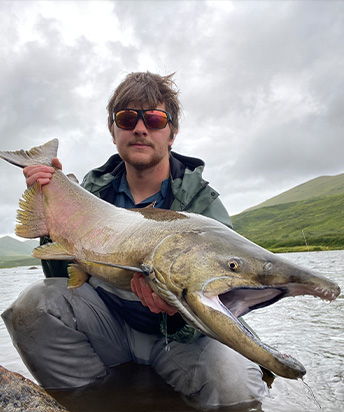 Simak holding fish in a boat
