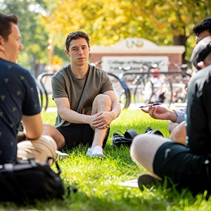 student conversation on grass outdoors