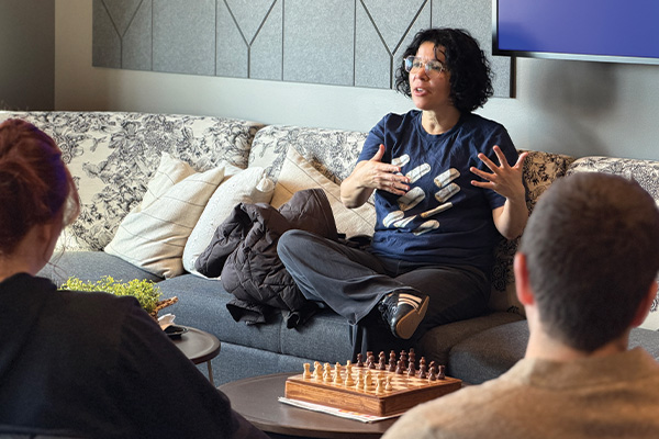 Speaker sitting on a couch talking with circle of guests